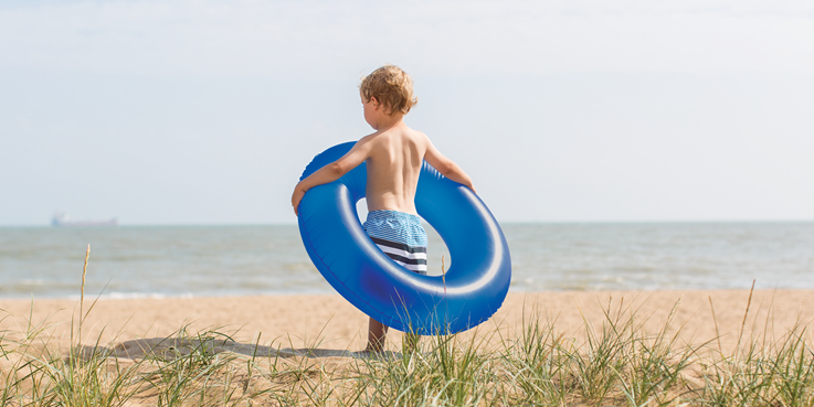 男孩在沙灘上抱著水泡